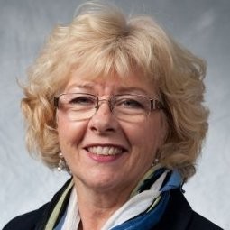 [small] Yvonne Fernandes portrait: woman with glasses and short wavy/curly hair in formal attire
